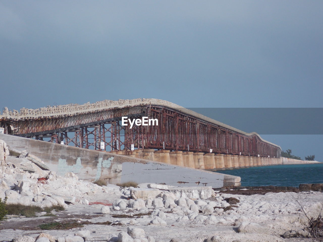 View of abandoned bridge over river against clear sky