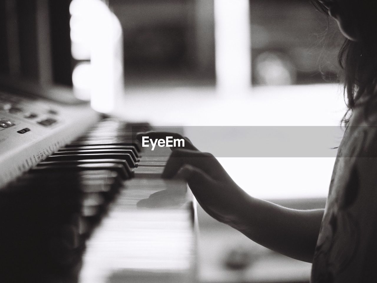 Midsection of girl playing piano