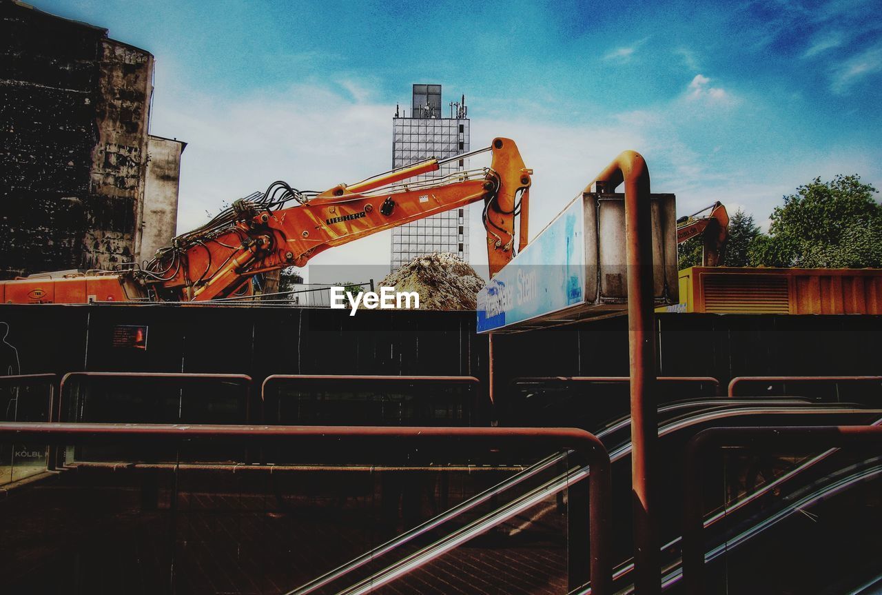 LOW ANGLE VIEW OF CRANES AT CONSTRUCTION SITE