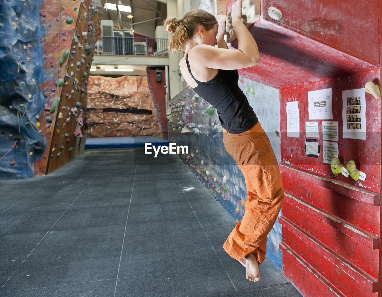 Woman training on fingerboard at indoor climbing gym