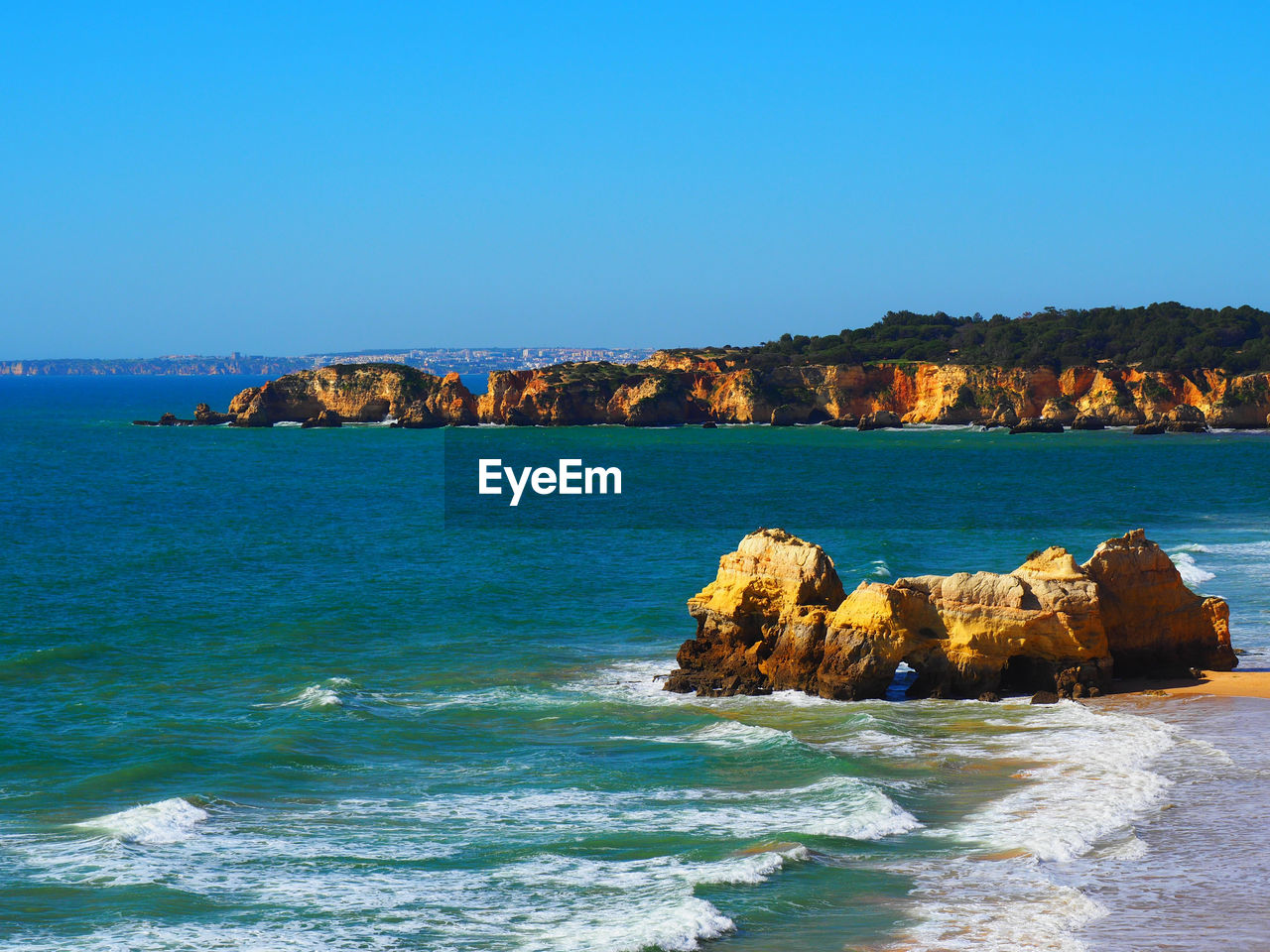 SCENIC VIEW OF SEA AND ROCKS AGAINST CLEAR SKY