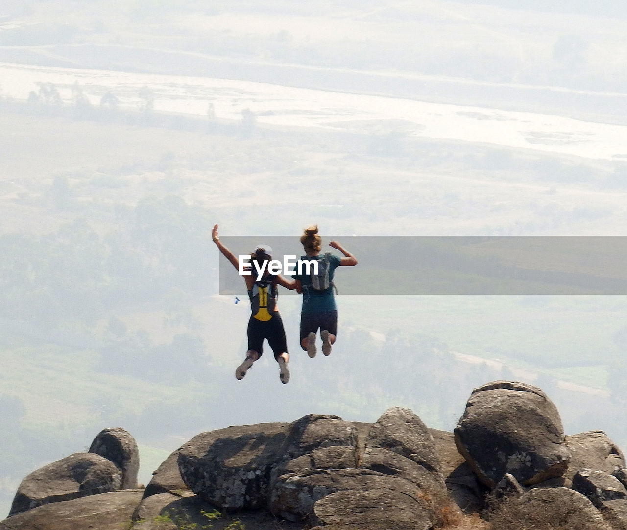 PEOPLE ENJOYING ON ROCKS AGAINST MOUNTAINS