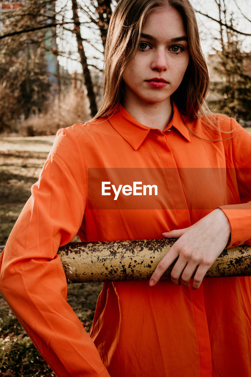 PORTRAIT OF BEAUTIFUL YOUNG WOMAN AGAINST PLANTS