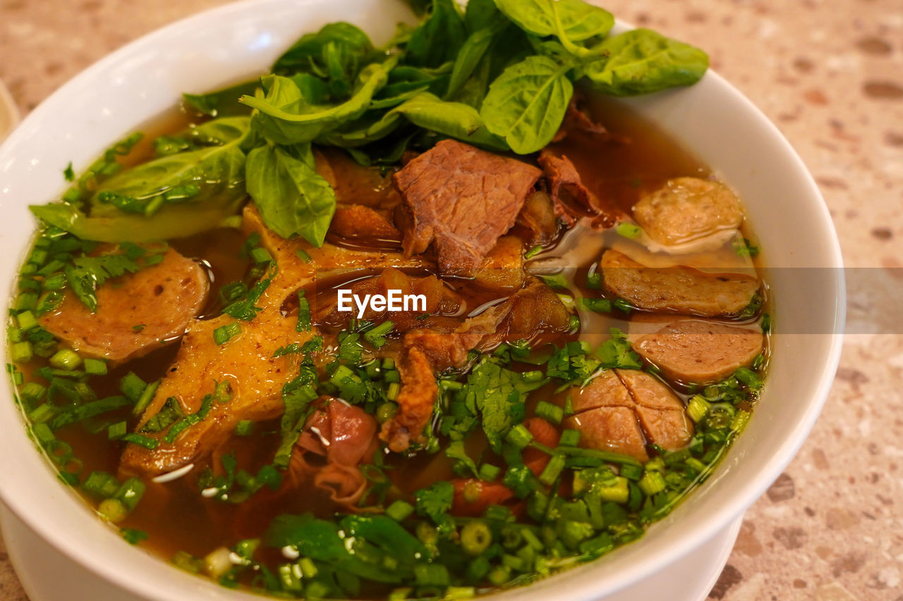 Pho bo or vietnamese soup with beef and meat balls served in a white bowl at the restaurant. 