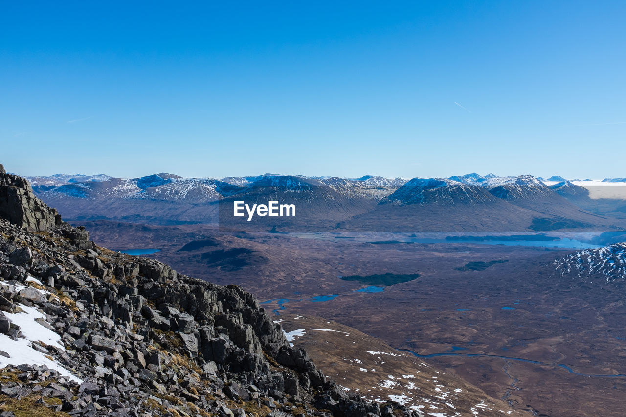 Scenic view of mountains against blue sky