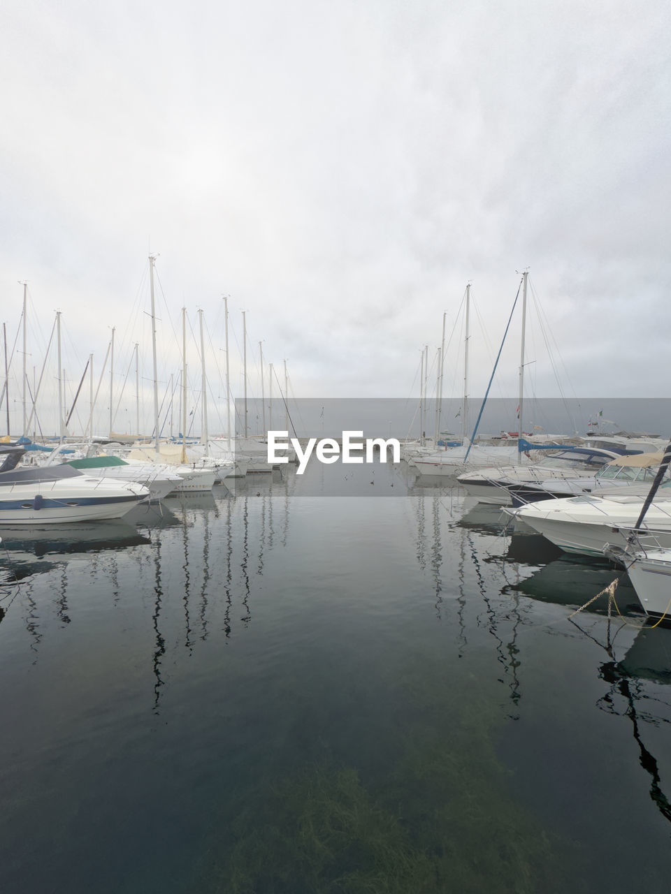 water, nautical vessel, transportation, marina, dock, sea, sailboat, sky, mode of transportation, moored, nature, harbor, reflection, cloud, no people, pole, ship, boat, tranquility, mast, vehicle, day, tranquil scene, beauty in nature, travel, scenics - nature, bay, outdoors, beach, watercraft, travel destinations, environment, idyllic, pier, holiday, yacht