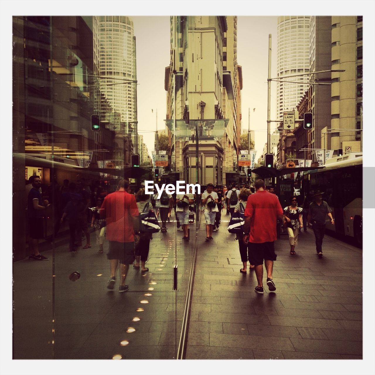 People walking on street by glass building