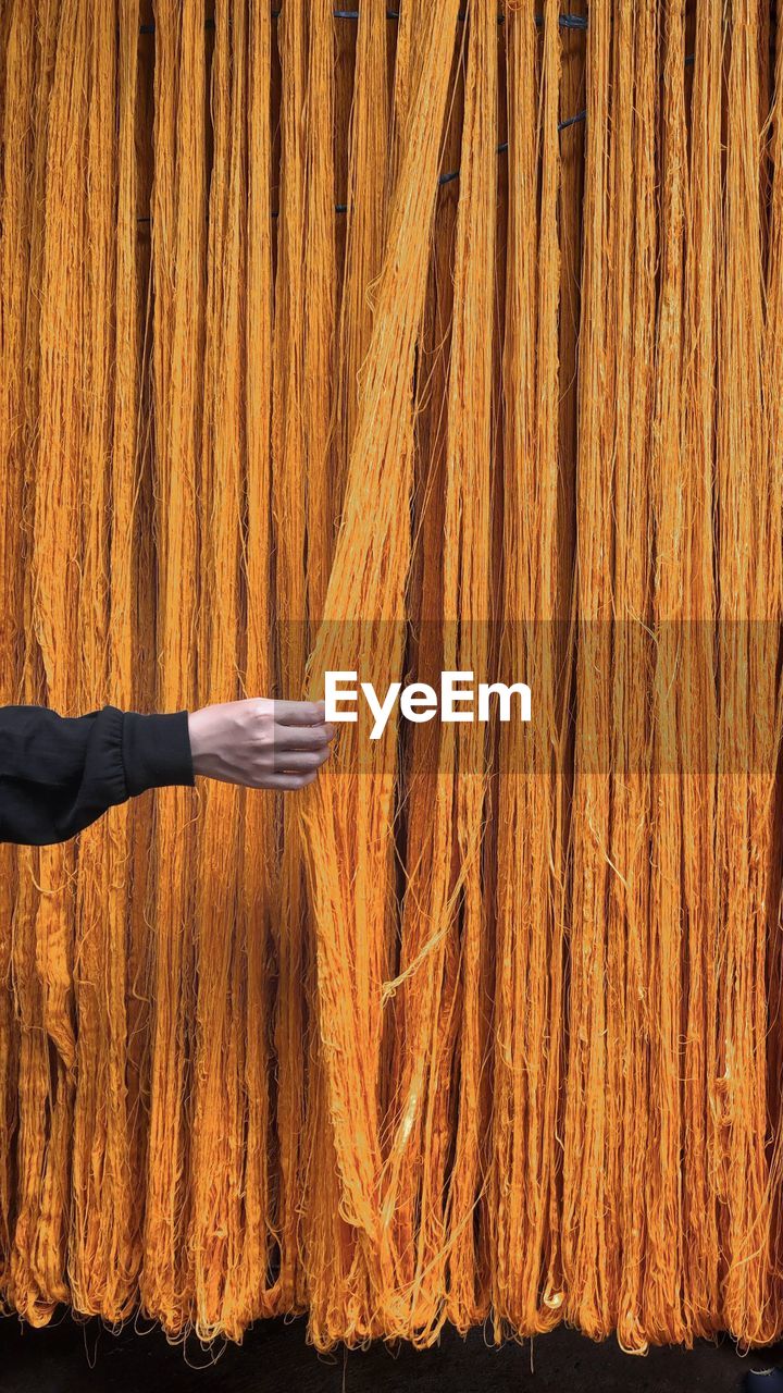 Cropped hand of woman standing against wall