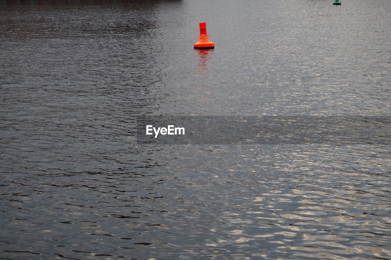 Orange distance marker floating on lake