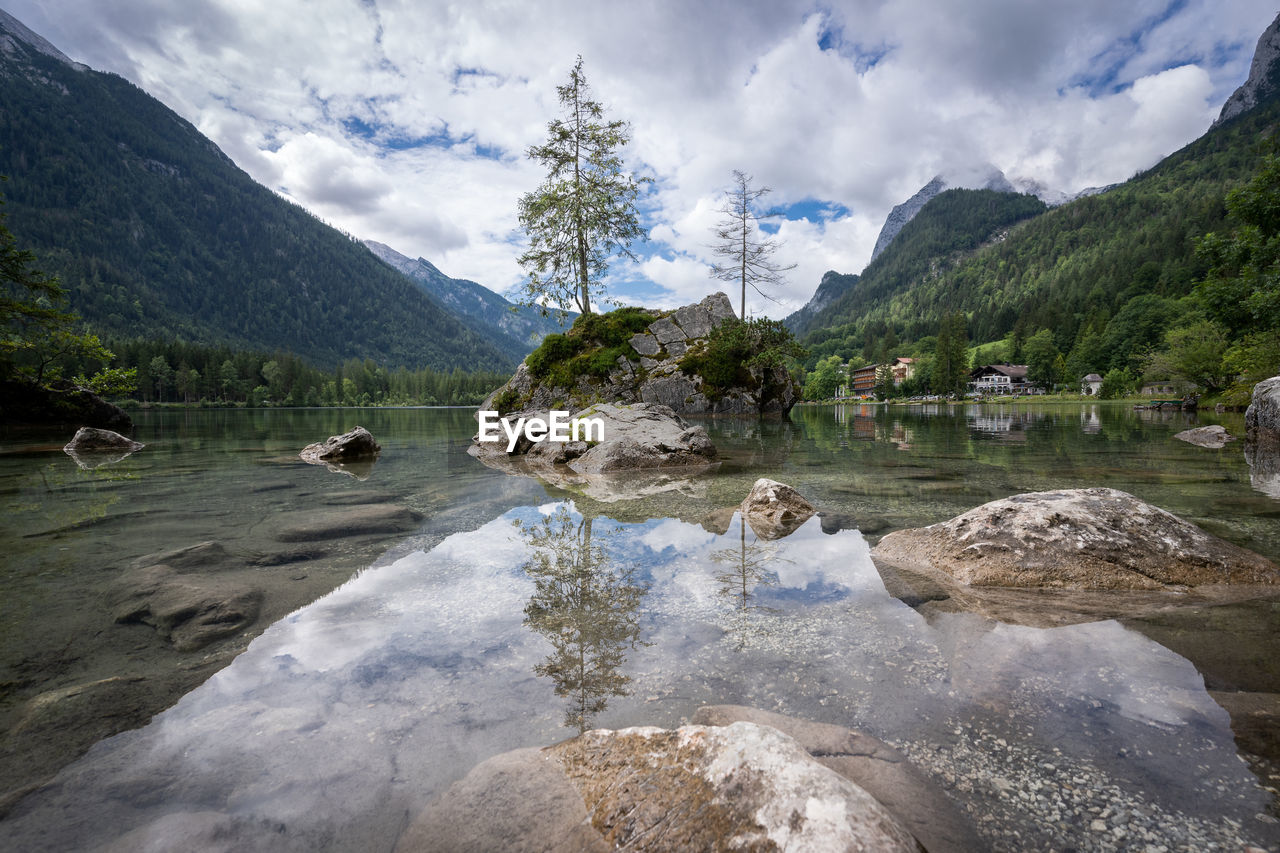 Crystal clear alpine tarn with rocky islands with tree on them, hintersee, germany