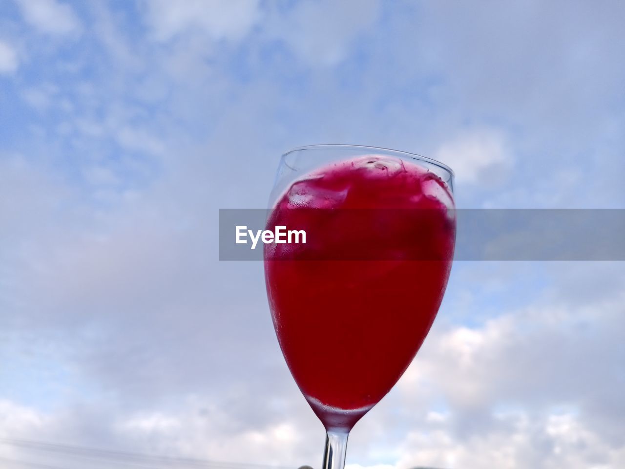 red, food and drink, sky, cloud, refreshment, glass, drink, alcohol, nature, alcoholic beverage, cocktail, freshness, drinking glass, wine, food, low angle view, no people, cosmopolitan, wine glass, pink lady, day, outdoors, close-up, fruit, household equipment, celebration, single object, blue