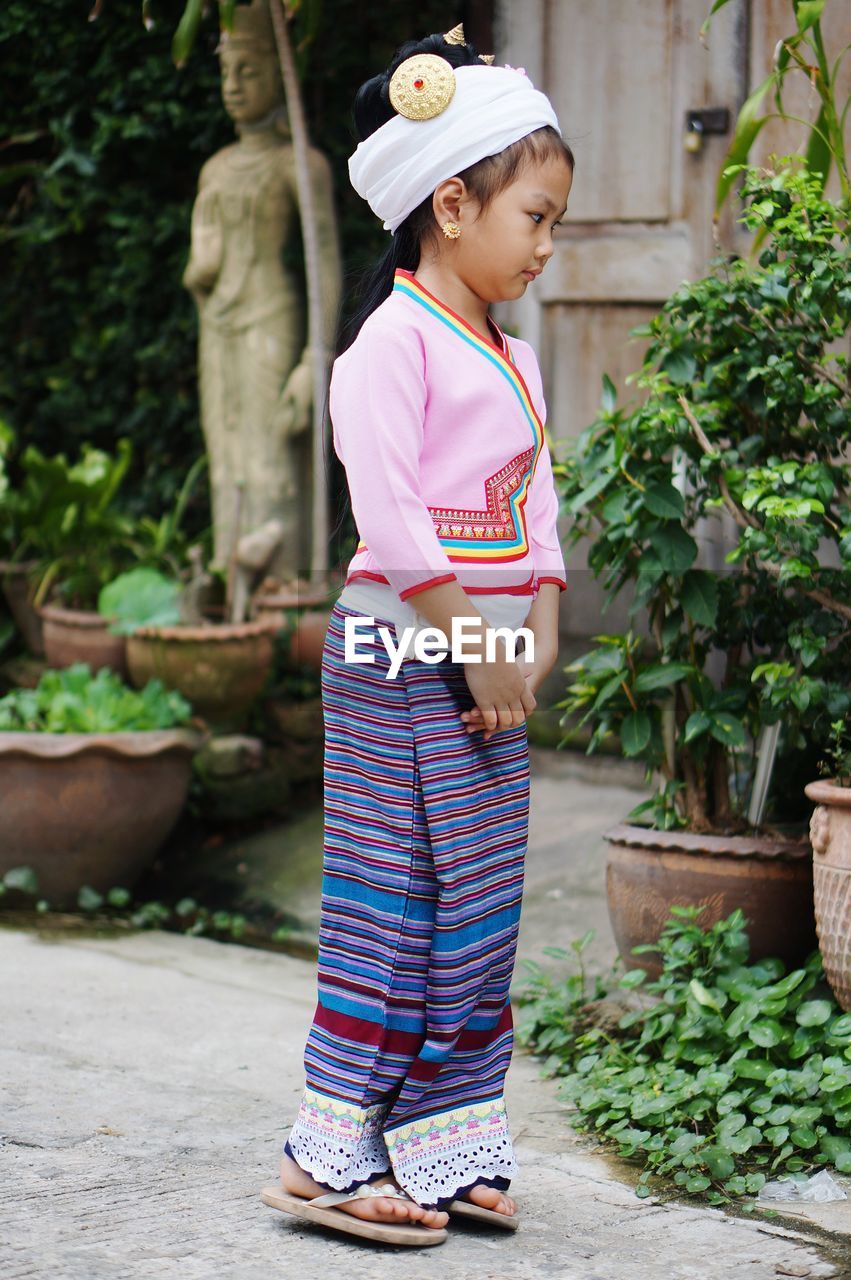 Full length of girl standing against plants