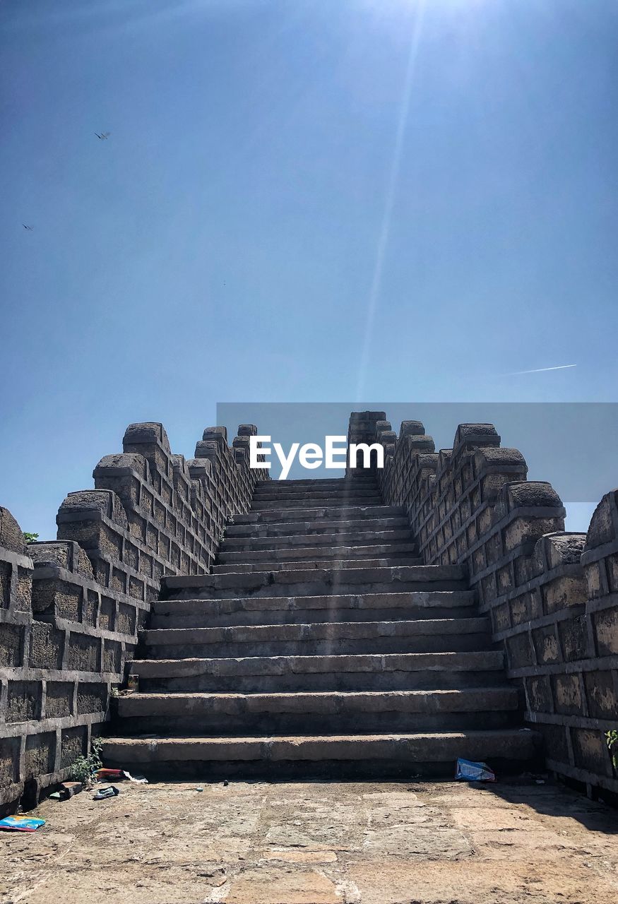 LOW ANGLE VIEW OF STAIRCASE AGAINST CLOUDY SKY