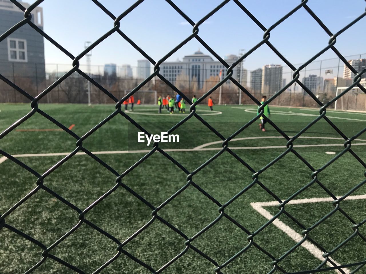 View of cityscape through chainlink fence