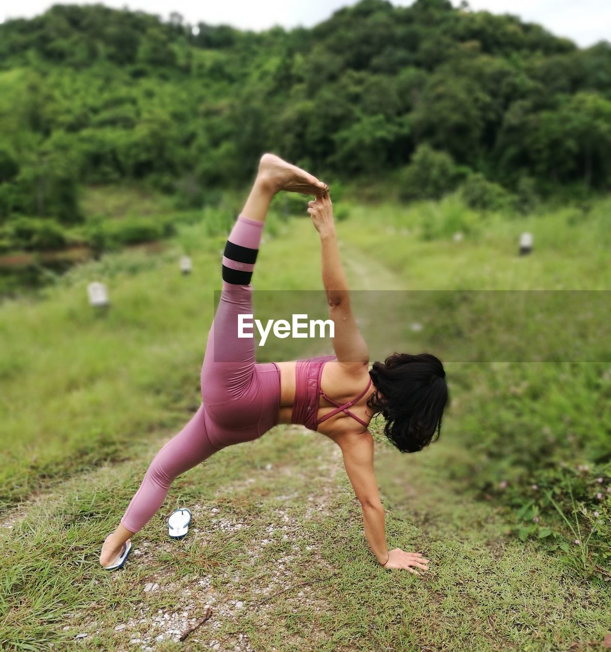 Rear view of woman exercising on field