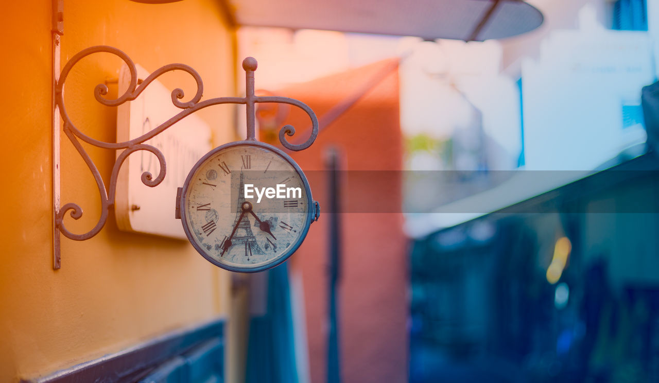 Close-up of clock hanging on wall outdoors