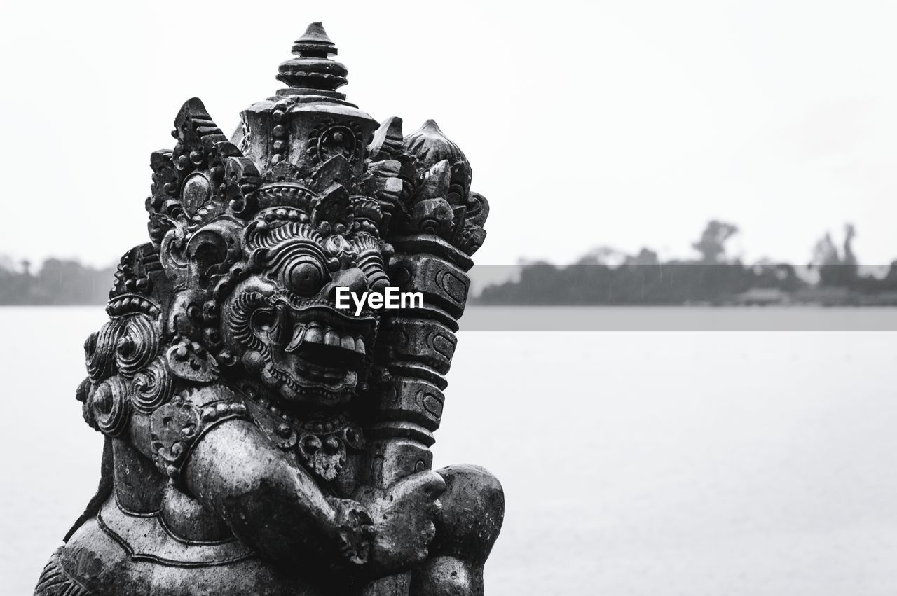 CLOSE-UP OF STATUE AGAINST SKY