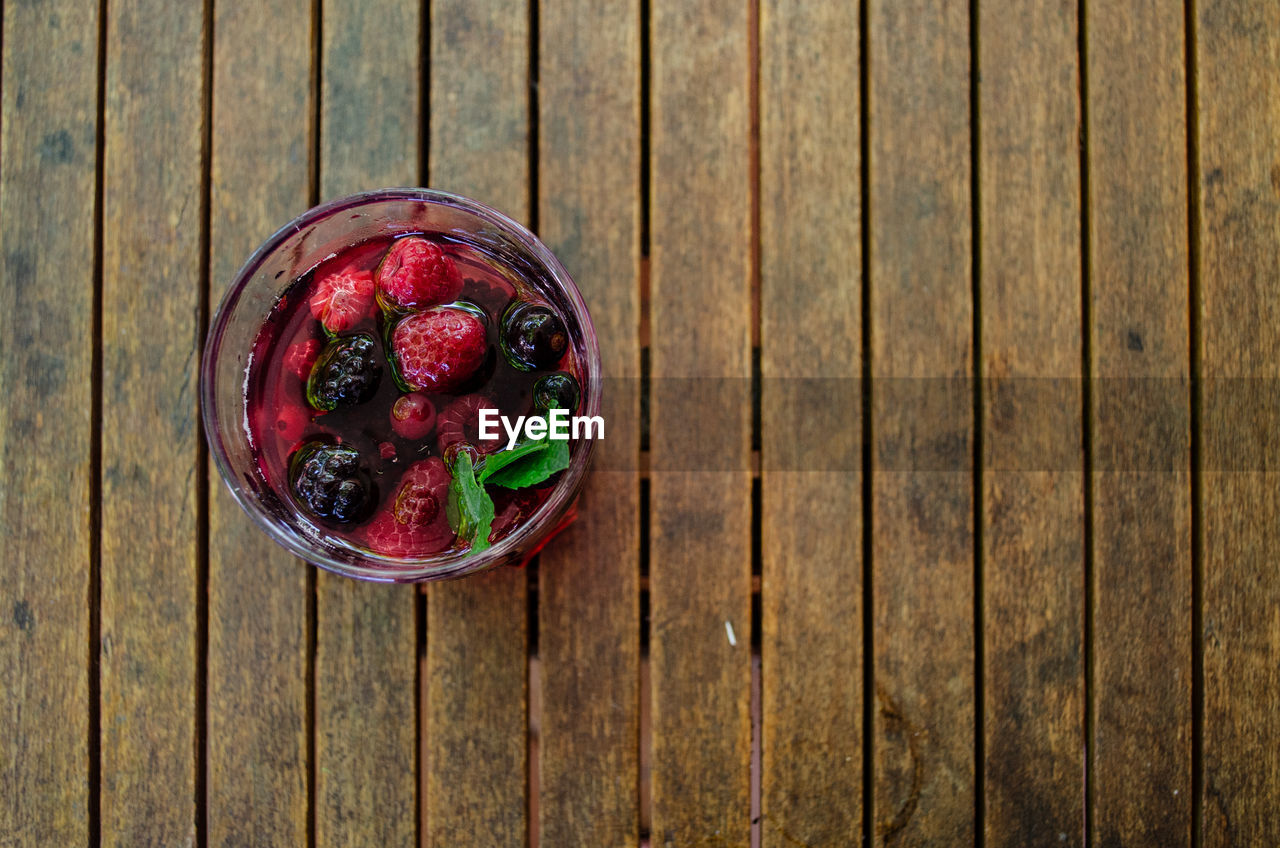 Directly above shot of bowl with raspberry on wooden table