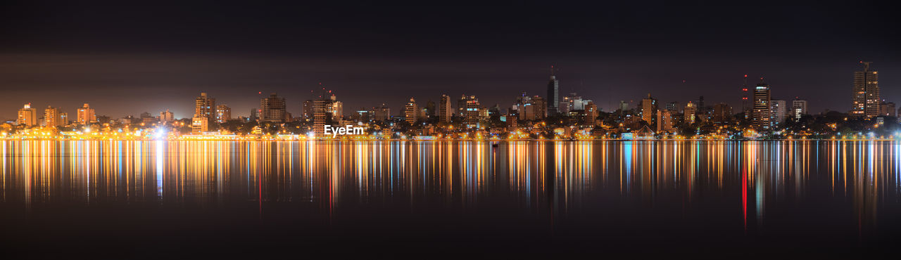 REFLECTION OF ILLUMINATED CITYSCAPE IN WATER