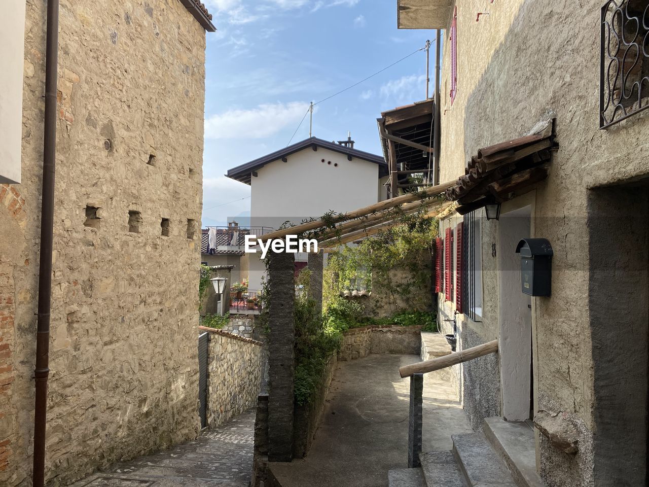 FOOTPATH AMIDST BUILDINGS AGAINST SKY