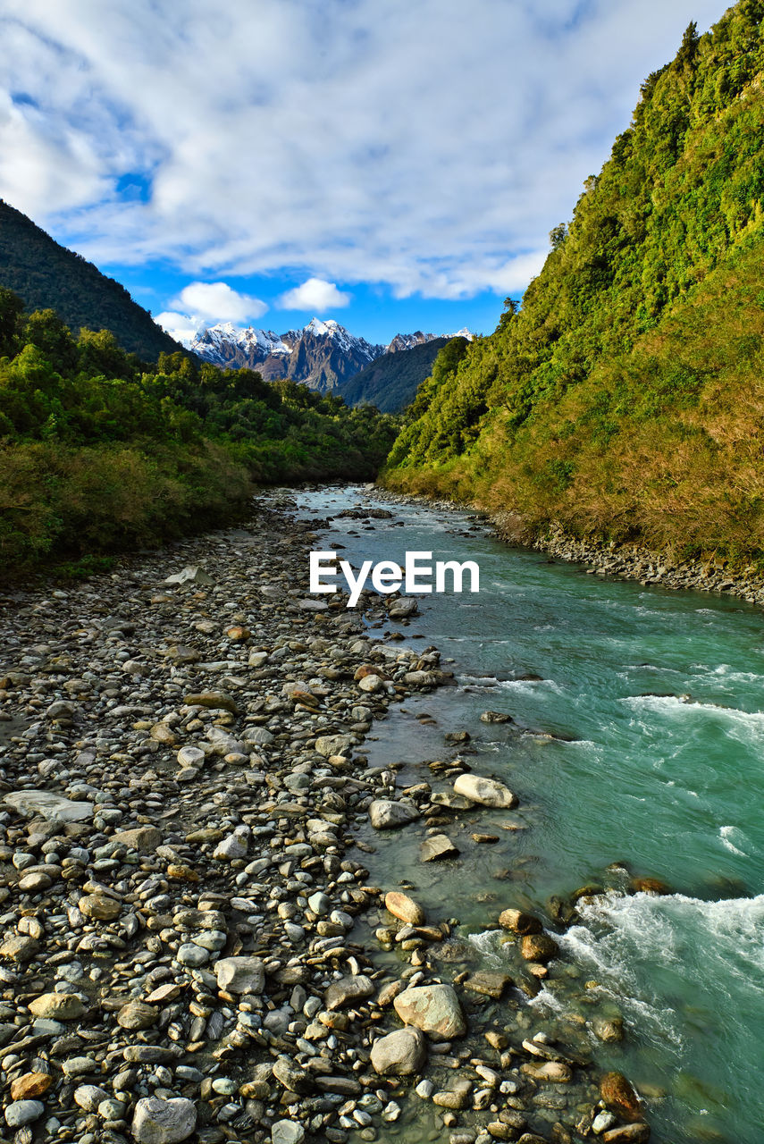 SCENIC VIEW OF RIVER AMIDST MOUNTAINS