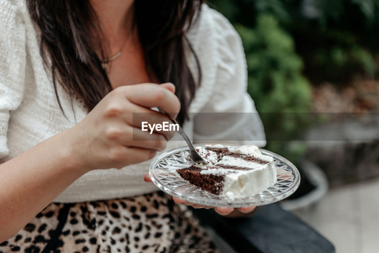 Close-up photo of woman eating cake