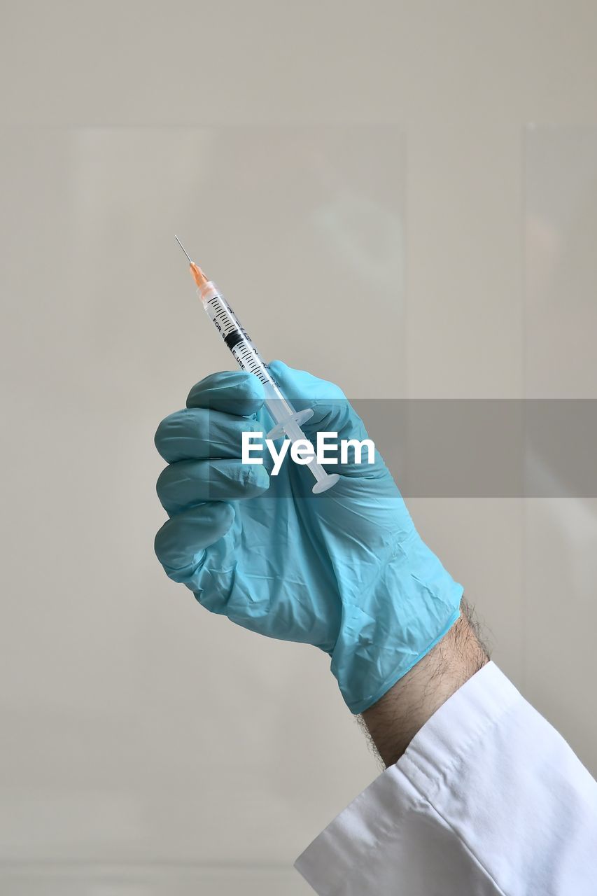 Cropped hand of doctor holding syringe