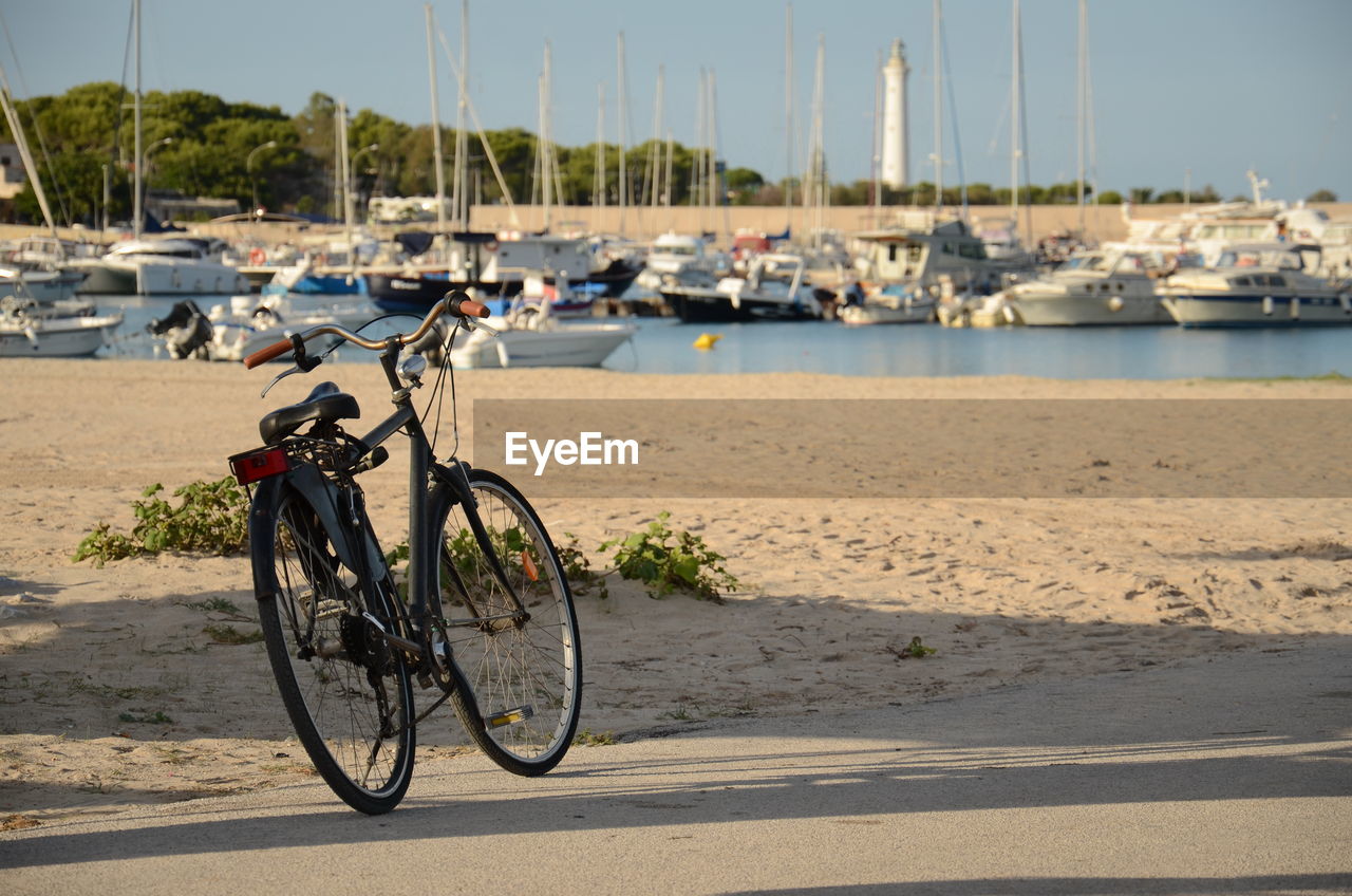 BICYCLES ON ROAD BY HARBOR