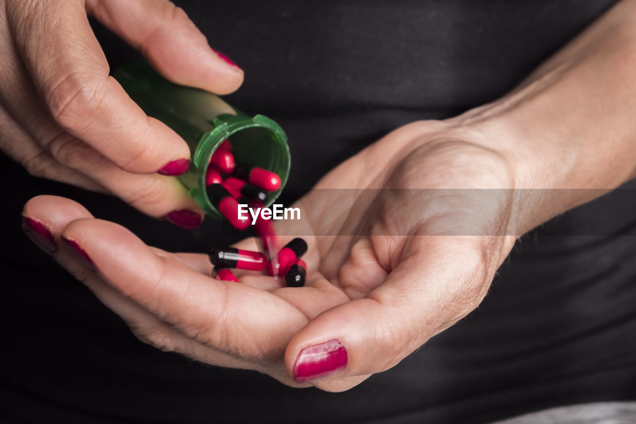 CLOSE-UP OF WOMAN HAND HOLDING RED PINK