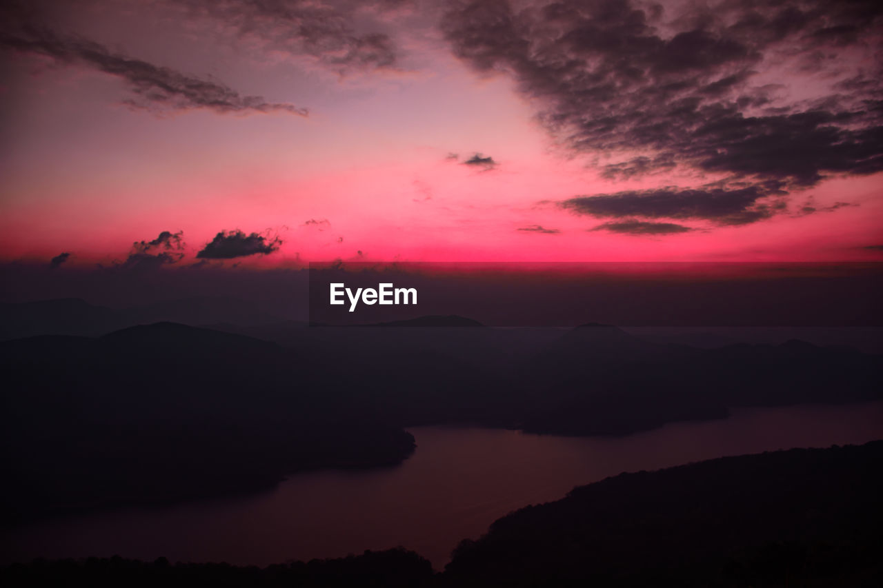 Scenic view of silhouette mountains against romantic sky at sunset