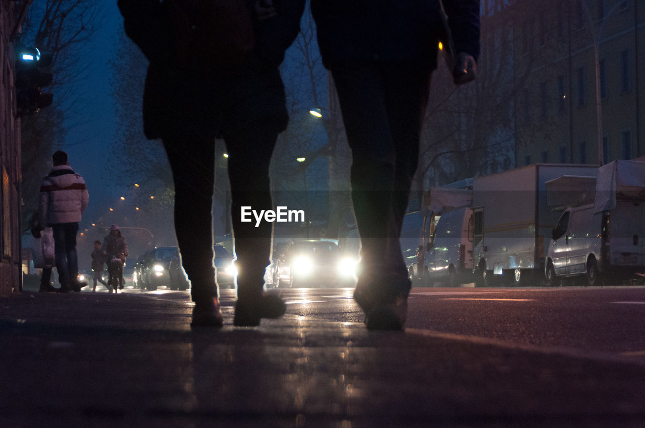 PEOPLE WALKING ON ROAD AT NIGHT