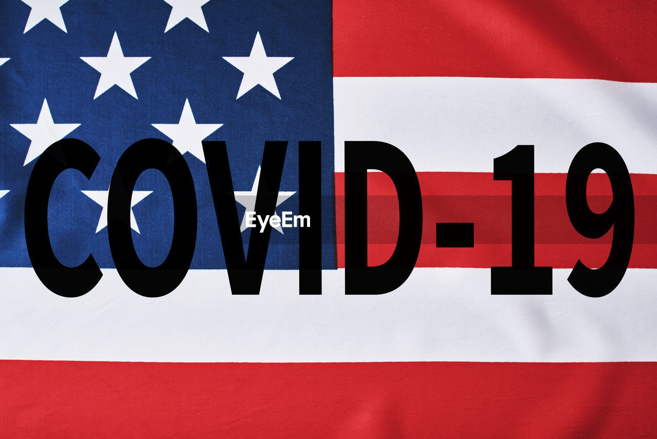 Close-up of covid-19 text over american flag