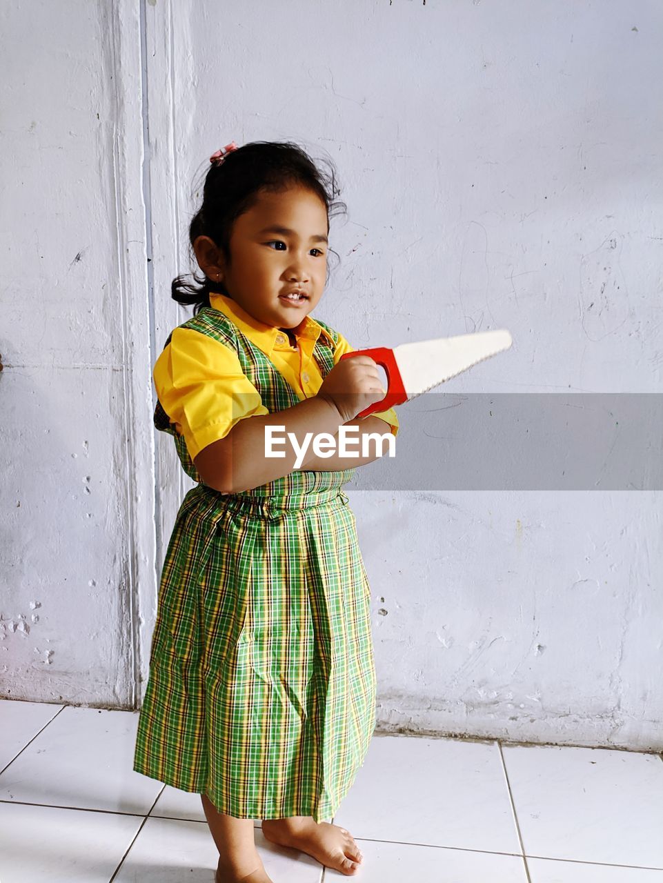 Side view of girl standing against wall