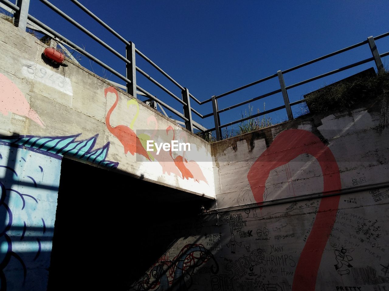 GRAFFITI ON WALL AGAINST CLEAR BLUE SKY