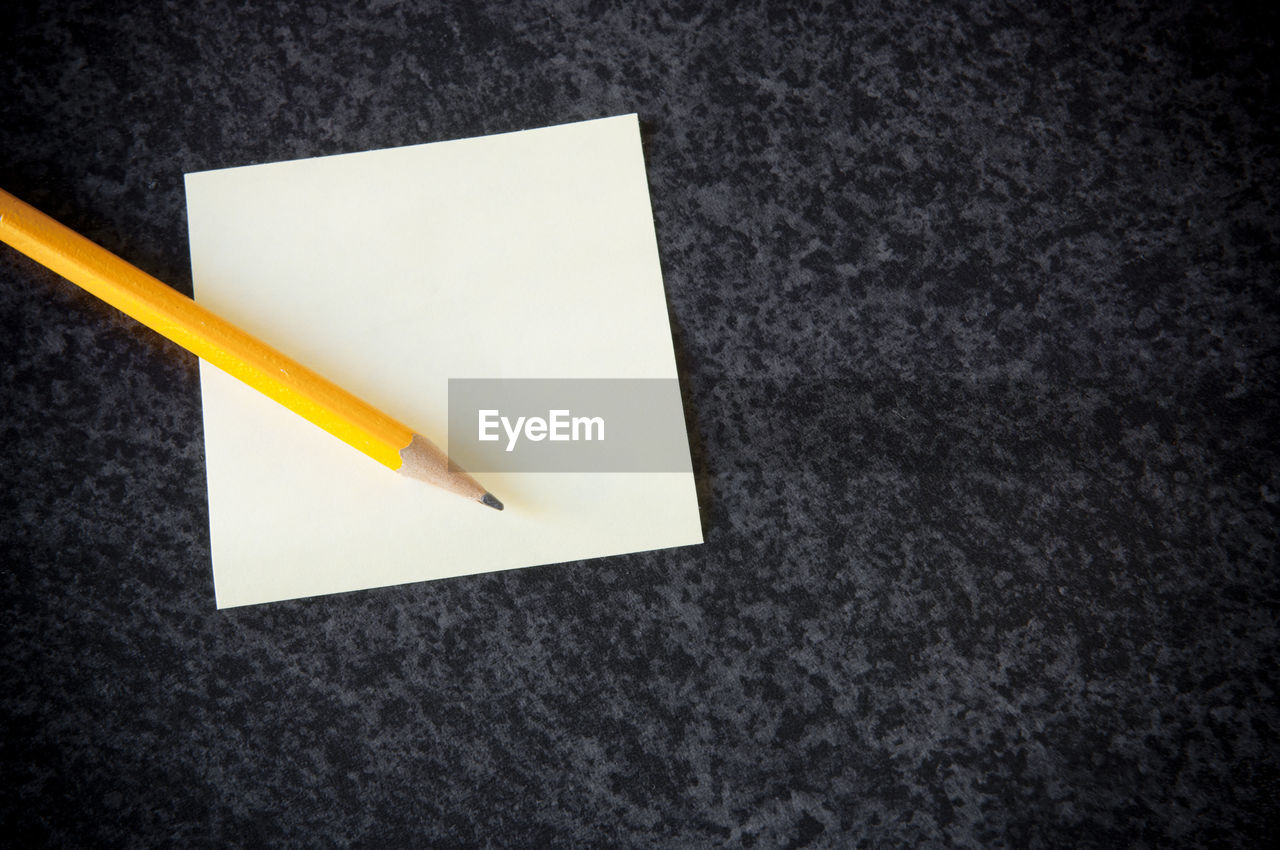 HIGH ANGLE VIEW OF PENCILS ON PAPER