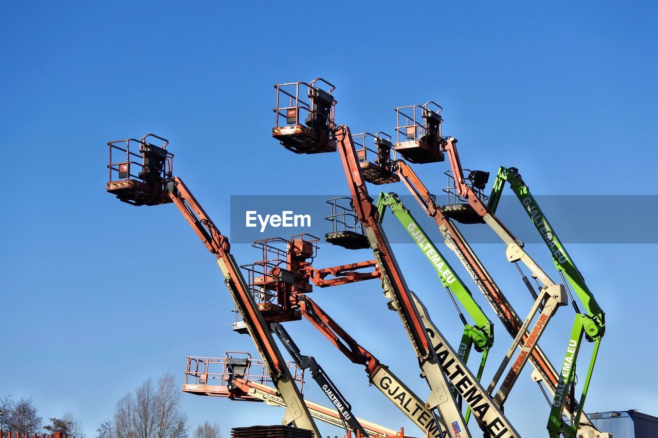 LOW ANGLE VIEW OF AMUSEMENT PARK RIDE AGAINST BLUE SKY