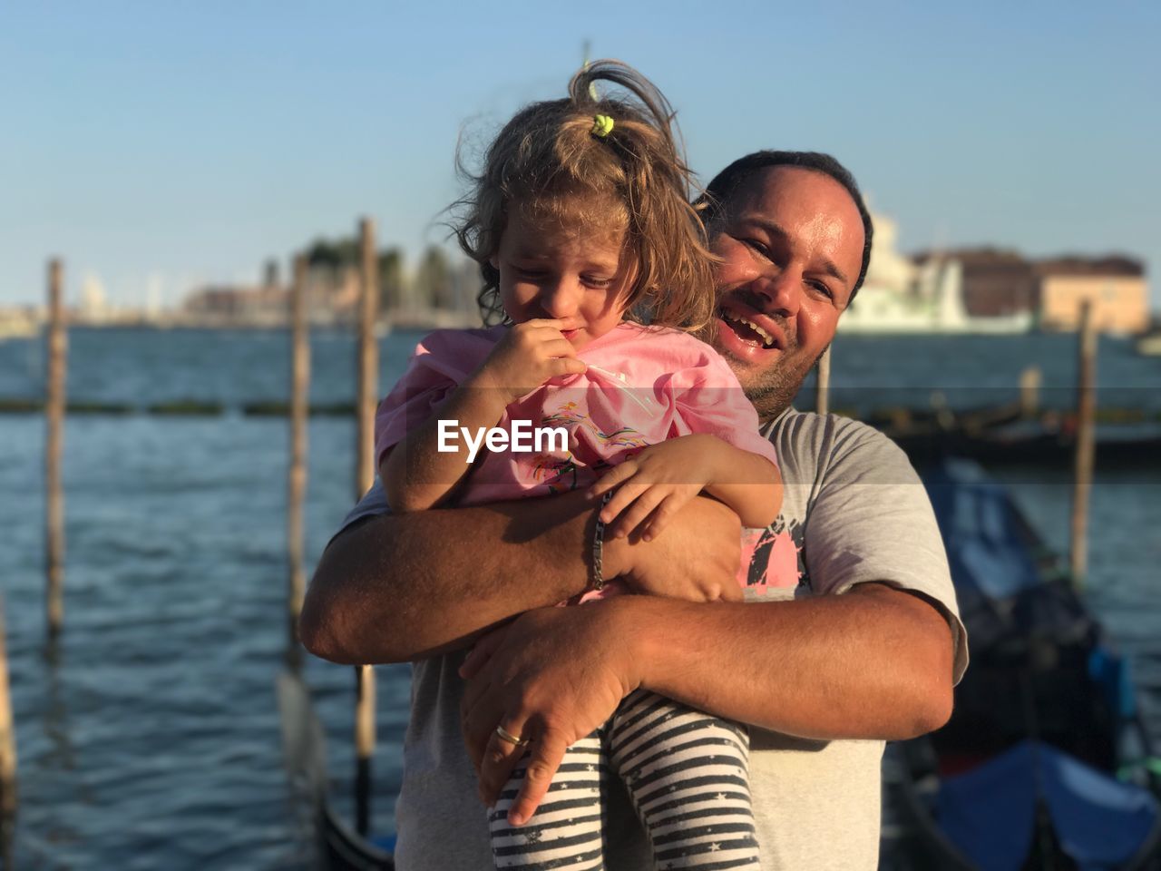 Portrait of man holding daughter while standing against grand canal