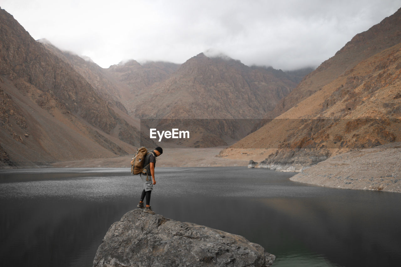 Man standing on rock against mountains