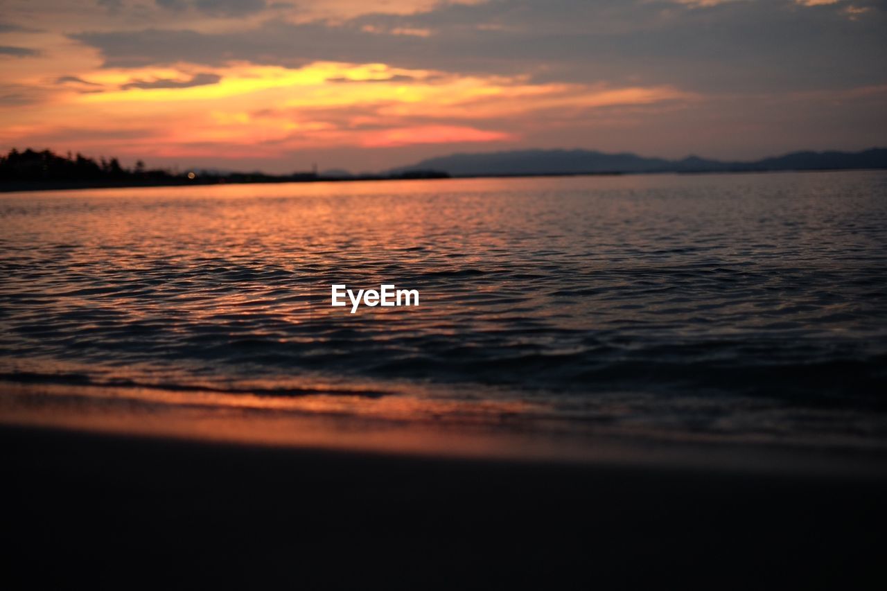 View of calm beach at sunset