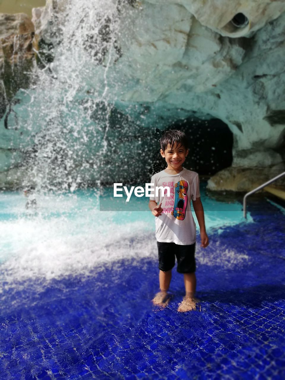 FULL LENGTH PORTRAIT OF HAPPY GIRL STANDING IN WATER