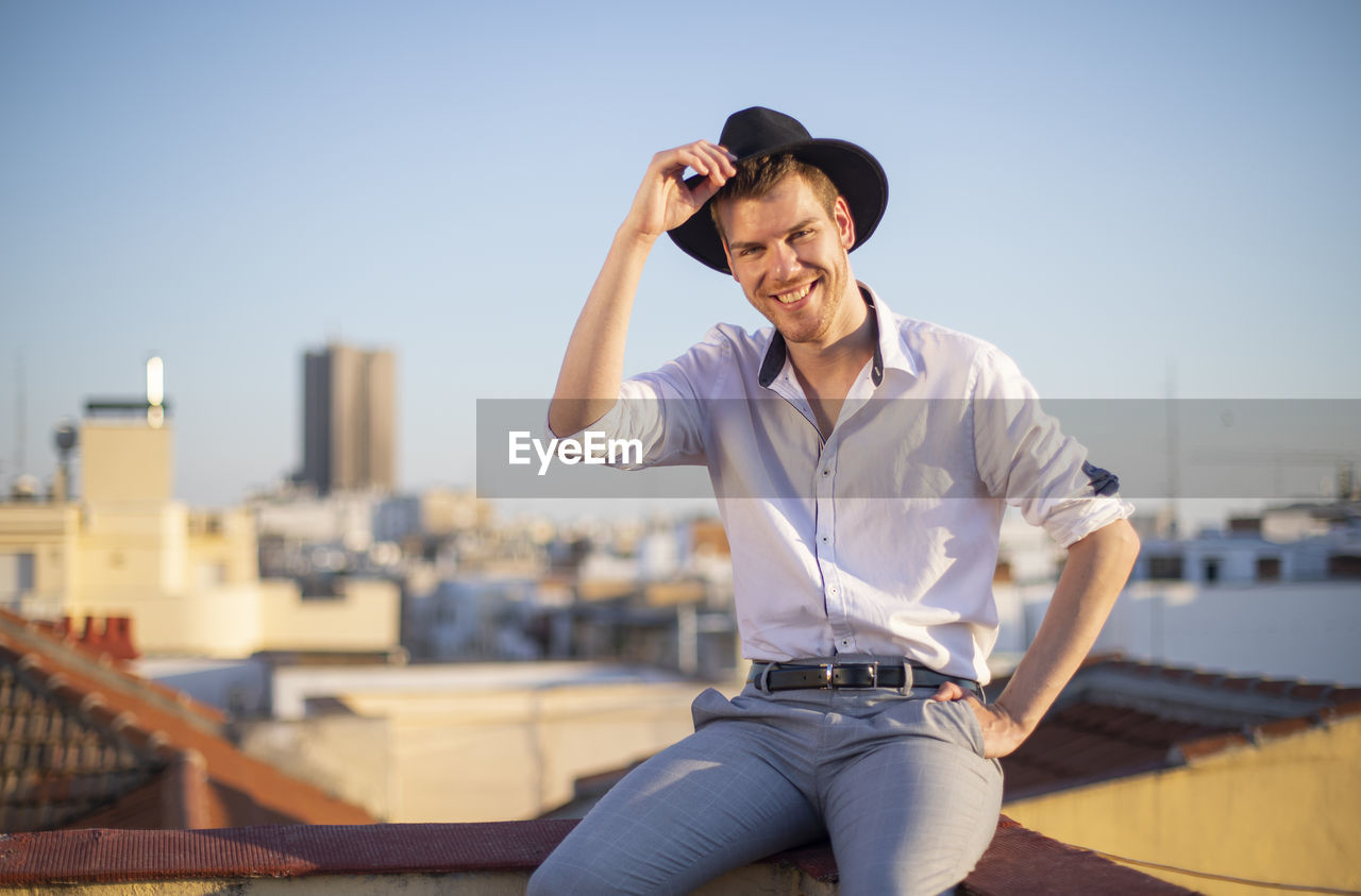 Smiling young boy with hat on the roof of a building