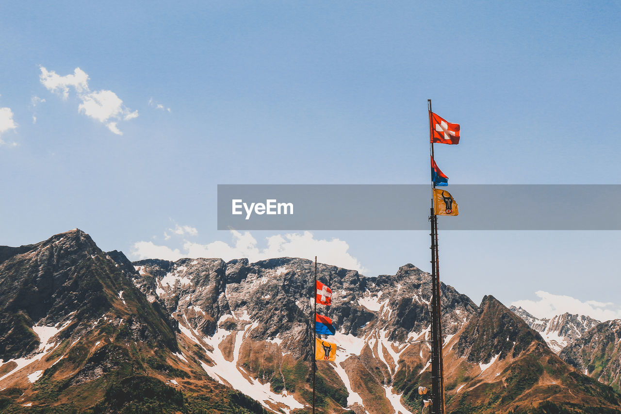 Information sign on snowcapped mountain against sky