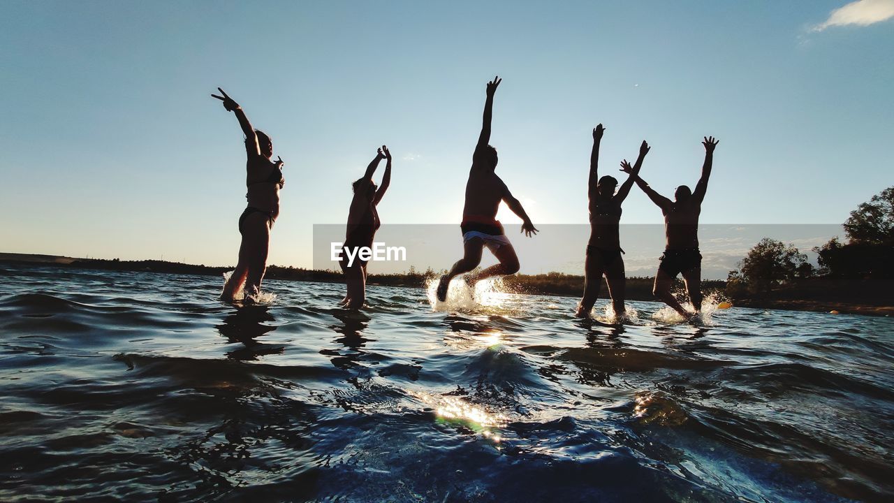 GROUP OF PEOPLE AT BEACH AGAINST SKY