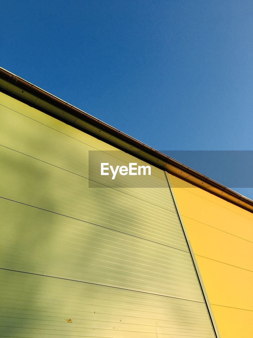 yellow, architecture, sky, line, built structure, no people, blue, building exterior, facade, clear sky, low angle view, sunlight, wood, nature, copy space, light, building, outdoors, day, wall, pattern, window covering, reflection, city, sunny, metal