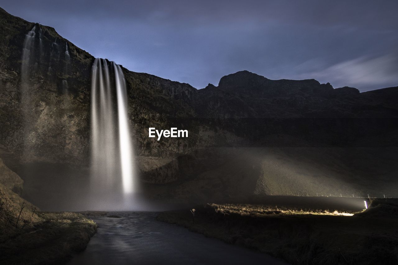 Scenic view of waterfall against sky