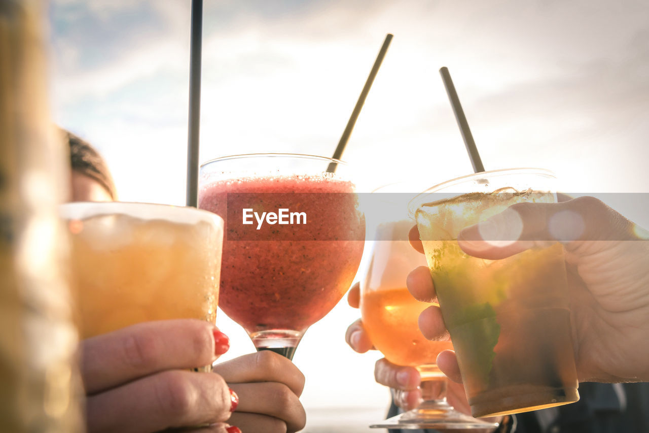 Greetings to best friends, group of friends enjoying evening drinks at the beach at sunset.