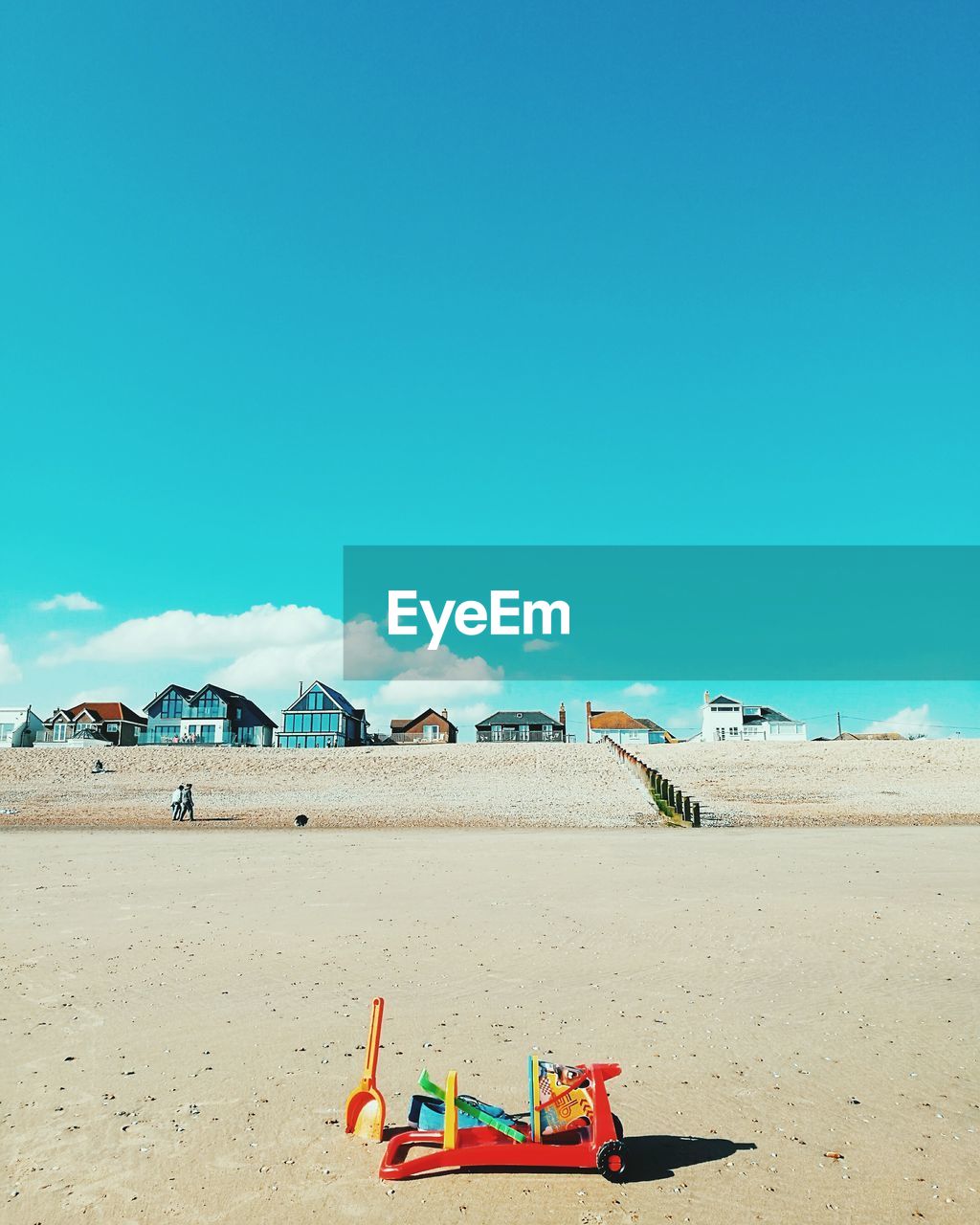 Toys at beach against blue sky during sunny day