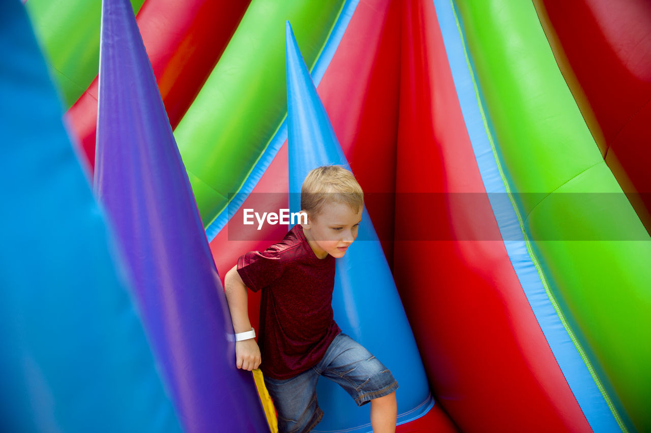 Boy playing on colorful bouncy castle