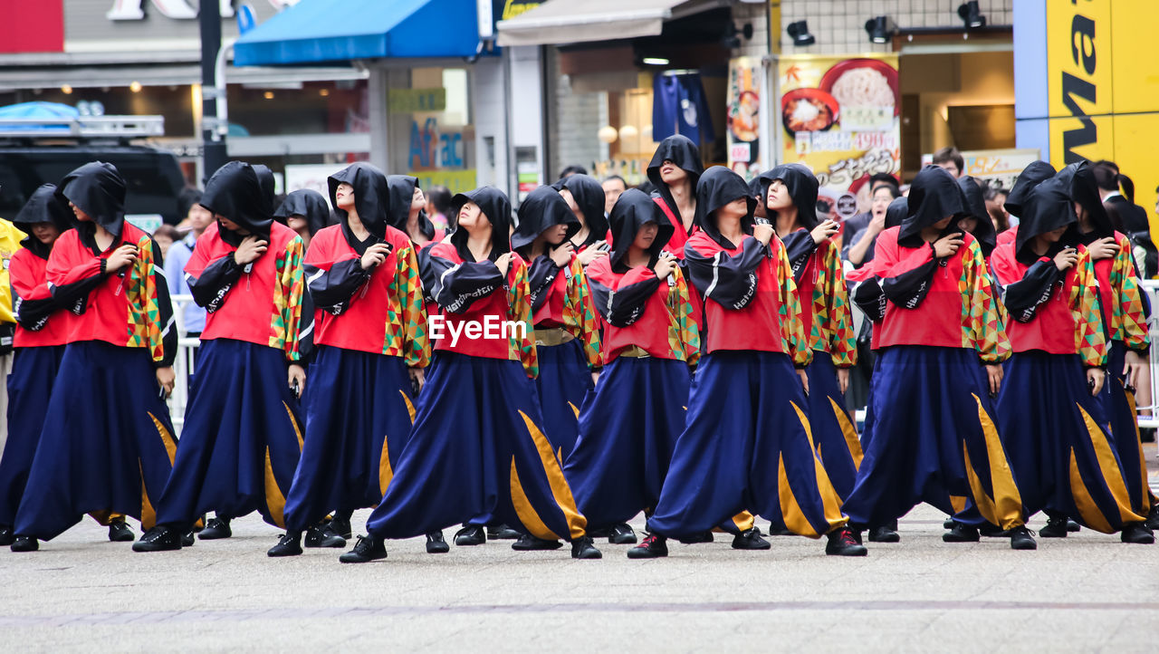 CROWD STANDING ON STREET DURING FESTIVAL