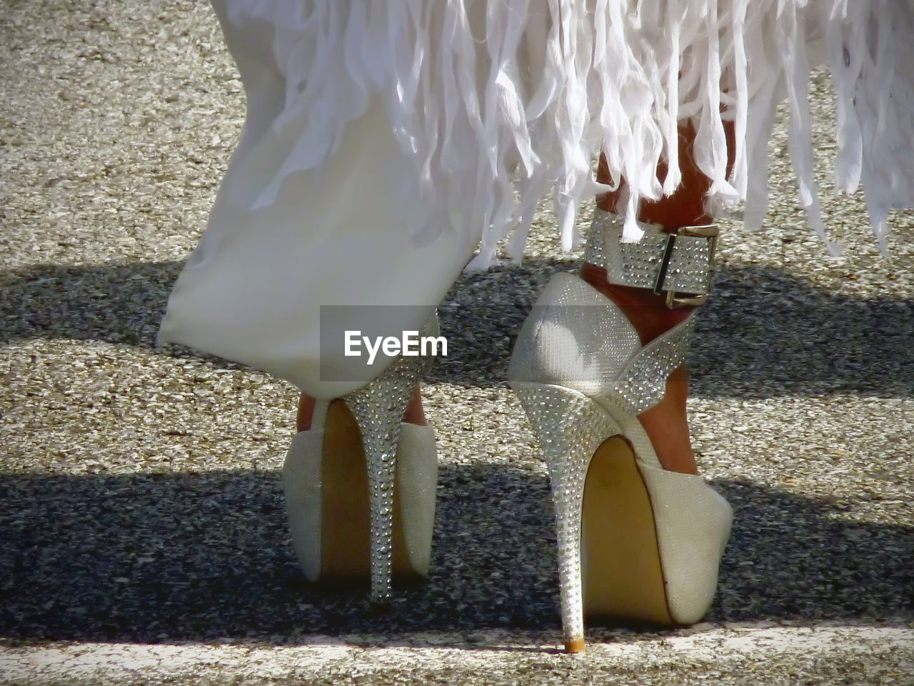 Woman wearing white glittering stiletto standing on street